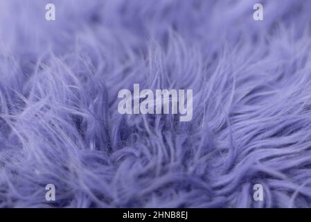 Purple soft fur for background or texture. Fluffy blue fur blanket. The color of 2022 very peri. Flat lay, top view, copy space. Stock Photo