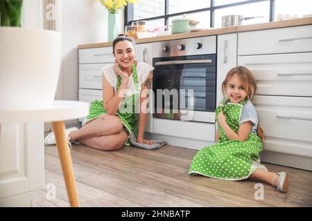 Little girl and her mother waiting for baking Easter cake in kitchen Stock Photo