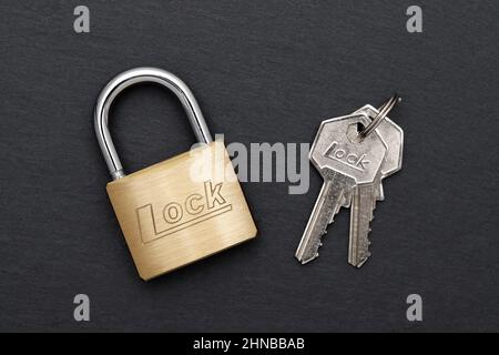 Steel padlock with key on a black background Stock Photo