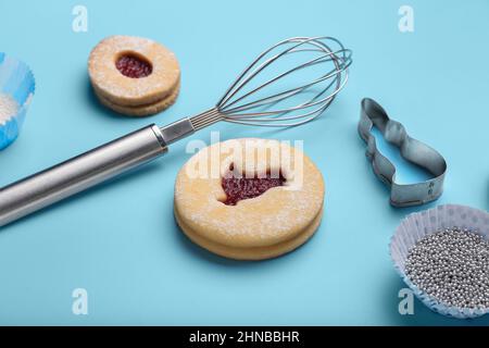 Delicious Easter cookies and utensils on blue background Stock Photo