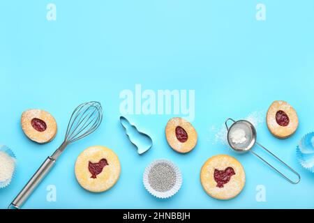 Delicious Easter cookies and utensils on blue background Stock Photo