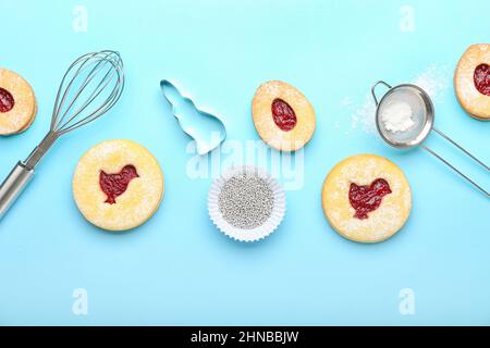 Delicious Easter cookies and utensils on blue background Stock Photo