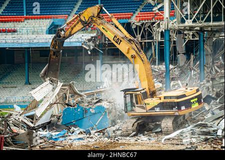 A yellow excavator demolishing Detroit Tiger Stadium Stock Photo