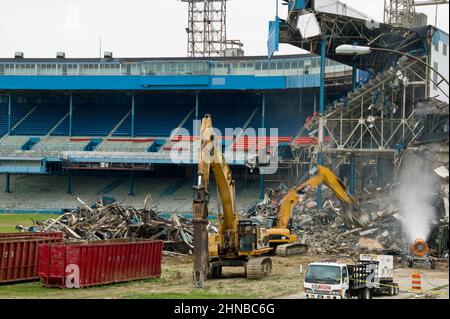 A yellow excavator demolishing Detroit Tiger Stadium Stock Photo