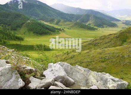The Chuisky Tract road is down among the green mountains in summer. Altai, Siberia, Russia Stock Photo