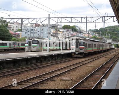 JR Hokkaido commuter trains, including the 731 and 733 series, are stationed at the platforms of Otaru Station in Hokkaido, Japan, on August 14, 2014. Stock Photo