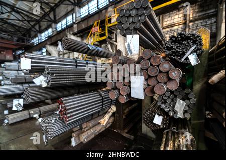 Rolled metal warehouse. Many packs of metal bars on the shelves Stock Photo