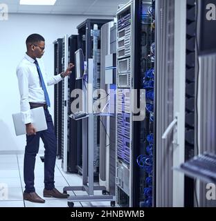 Running diagnostics. Cropped shot of a IT technician working and checking if all the servers are up and running. Stock Photo