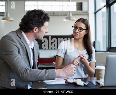 Going over the key points. Cropped shot of two business colleagues discussing work in the office. Stock Photo