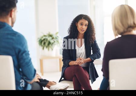 And how does that make you feel. Shot of a young therapist speaking to a couple during a counseling session. Stock Photo