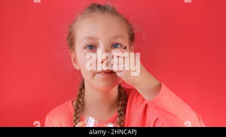 Child eating yogurt jelly pink background. Dairy product diet Lactobacillus Acidophilus, healthy homemade breakfast menu. Kids healthcare. Vegan food Stock Photo