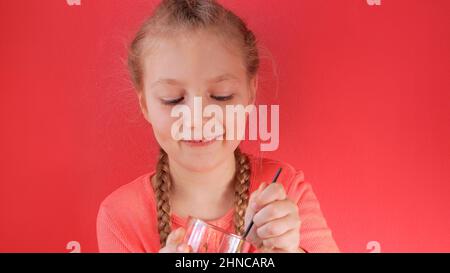 Child eating yogurt jelly pink background. Dairy product diet Lactobacillus Acidophilus, healthy homemade breakfast menu. Kids healthcare. Vegan food Stock Photo