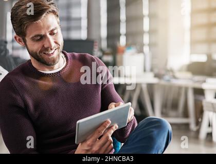 Marketing his business in a virtual world. Shot of a young man using a digital tablet in an office. Stock Photo