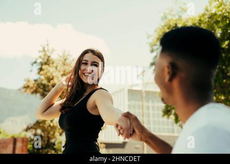 Young couple walking in the park holding hands Stock Photo