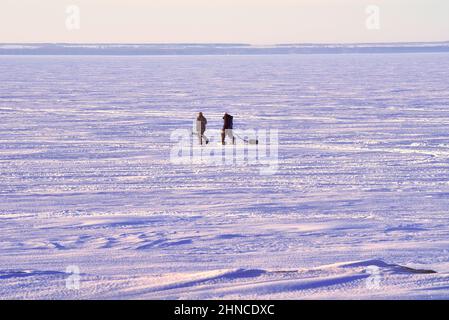 Novosibirsk, Siberia, Russia-04.03.2021: Fishermen on the winter Ob Sea. Fans of ice fishing go on the ice of the Novosibirsk reservoir away from the Stock Photo