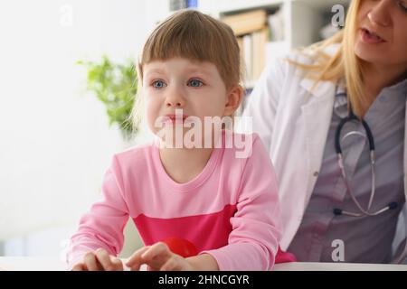Girl cry at doctor office on consultation, upset little girl dont like hospital Stock Photo