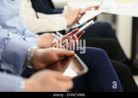 People using mobile phones on meeting, modern gadgets in work Stock Photo