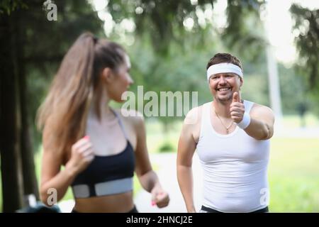 Tired middle aged man running in early morning with woman friend Stock Photo