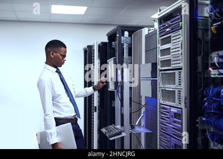 Everything seems to be in order. Cropped shot of a IT technician working and checking if all the servers are up and running. Stock Photo
