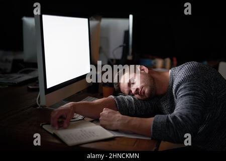 Ill just rest my eyes for a moment. Shot of a tired computer programmer sleeping at his desk. Stock Photo