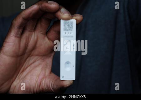 Person of African ethnicity holding a single positive Covid-19 rapid home lateral flow antigen test Stock Photo