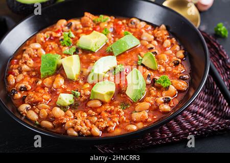 Chili con carne in bowl on dark background. Mexican cuisine. Stock Photo