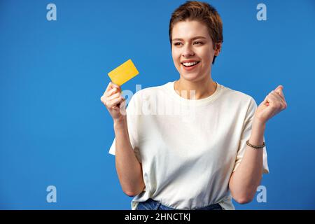 Image of young woman holding business card with copy space on blue background Stock Photo