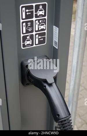 24 January 2022, Kaiserslautern, Germany, Close up of a plugin charging station for electric cars, focus on plugin, green mobility (vertical)
