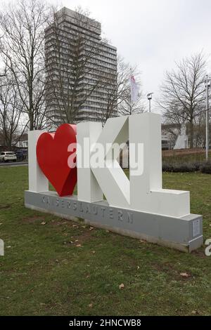 24 January 2022, Kaiserslautern, Germany, White and red sculpture 'I love Kaiserslautern', town hall in the background (vertical)