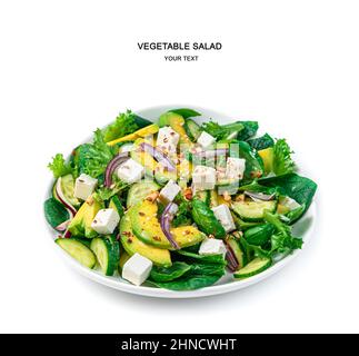 Fresh vegetable salad with avocado, cucumber, feta and herbs seasoned with nuts and sesame seeds and flax is isolated on a white background. Side view Stock Photo