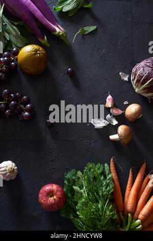 From above still life with fresh fruits and vegetables on dark background Stock Photo