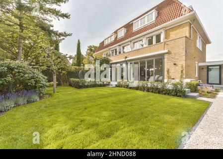 Terrace of residential building with grassy lawn and green trees ...