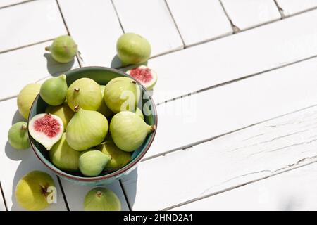 Fresh green figs bowl on white wooden table Stock Photo