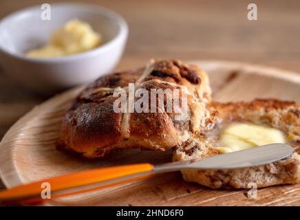 A toasted and buttered Hot Cross Bun, a sweet spiced bun traditionally eaten on Good Friday Stock Photo