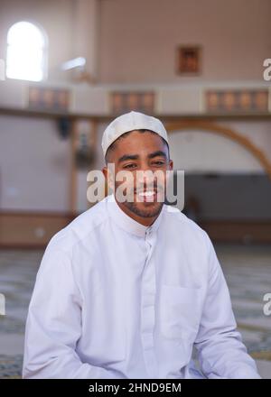 A Muslim man in a mosque smiling Stock Photo