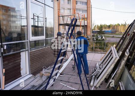 Replacement of double-glazed windows in shop windows, reconstruction of the supermarket facade, repair of windows, Workers installing glass windows on Stock Photo