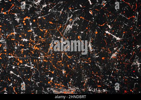 Abstract textured painted dark gray background with orange and white inclusions. Stock Photo