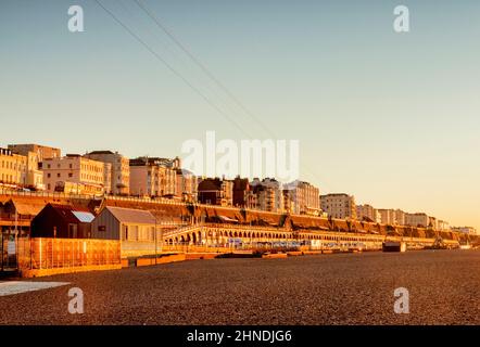 14 January 2022: Brighton, East Sussex, UK - Hotels on the seafront at Brighton, from the beach during winter sunrise. Clear blue sky. Stock Photo
