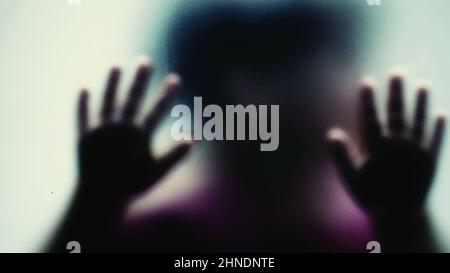 Defocused shot of a child behind glass feeling stuck abusive concept Stock Photo