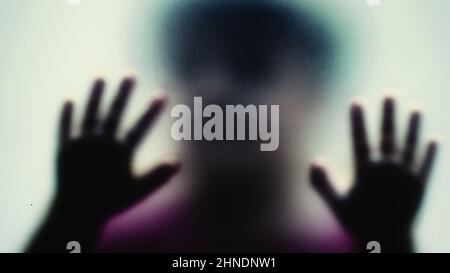 Defocused shot of a child behind glass feeling stuck abusive concept Stock Photo