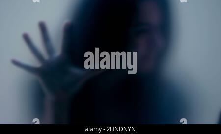 Defocused shot of person trapped in emotional problems behind glass ...