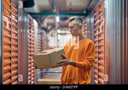 Experienced storehouse worker performing the packaging quality control Stock Photo