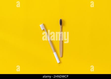 Two natural eco-friendly bamboo brushes with white and black bristles on paper yellow background. Zero waste concept.Copy space for text or your desig Stock Photo