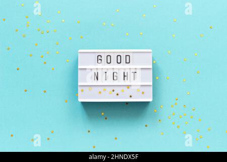 Lightbox text Good Night and gold star on blue paper background. Concept Sweet dreams Greeting card Top view Creative flat lay. Stock Photo