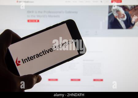 Rheinbach, Germany  24 February 2022,  The 'Interactive Brokers' brand logo on the display of a smartphone in front of the website Stock Photo