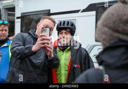 Winterbourne Abbas, Dorset, UK. 16th February 2022. Olympic gold medalists Tom Daley poses for selfies on day 3 of his Comic Relief Hell of a Homecoming Challenge from the Queen Elizabeth Olympic Park in London to his hometown of Plymouth in Devon. On this leg he is cycling 130 miles from Southampton to Bovey Castle on Dartmoor in Devon. Credit: David Partridge / Alamy Live News Stock Photo