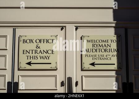 White signs with black lettering and arrows welcome visitors to the Ryman Auditorium in Nashville, Tennessee, and point to the box office and entrance. Stock Photo