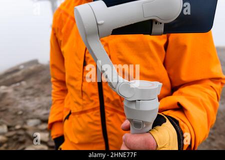 Man holding a stabilizer in his hands, close up of water droplets on a stabilizer. Stock Photo
