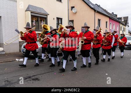 Bornheim, North Rhine-Westphalia, Germany - February 22, 2020: Brass band playing traditional carnival music and marching in red costumes at a parade. Stock Photo