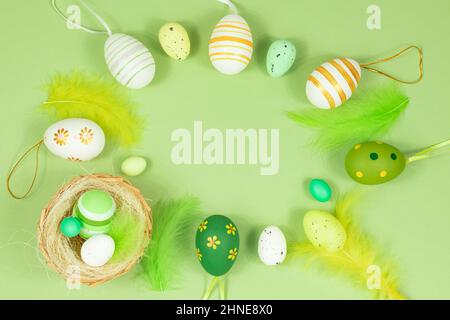 Happy easter. Delicate, pastel salad background with a nest, colorful eggs and feathers. View from above. Place for text. Stock Photo